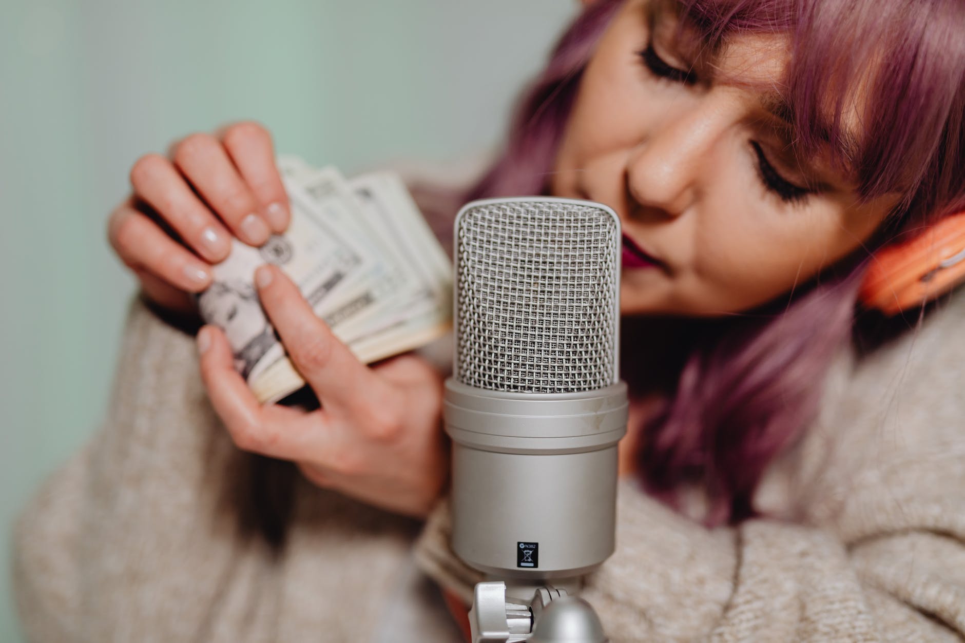 Singer with a microphone who is counting the money she made with youtube